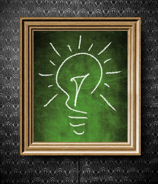 Idea concept light bulb chalkboard in old wooden frame — Stock Photo, Image