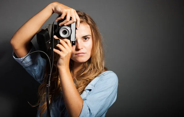 Photographer in jeans jacket taking pictures with old camera — Stock Photo, Image
