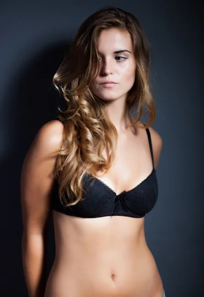 Portrét sexy ženy ve spodním prádle na tmavém pozadí — Stock fotografie