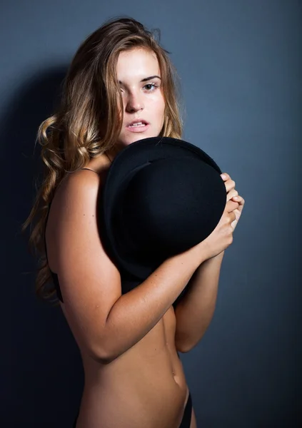 Naked woman in lingerie covering breast with hat — Stock Photo, Image