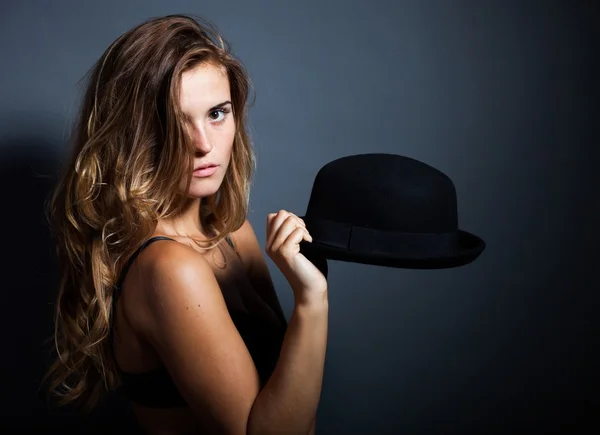 Mulher sexy em lingerie segurando seu chapéu, fundo escuro — Fotografia de Stock