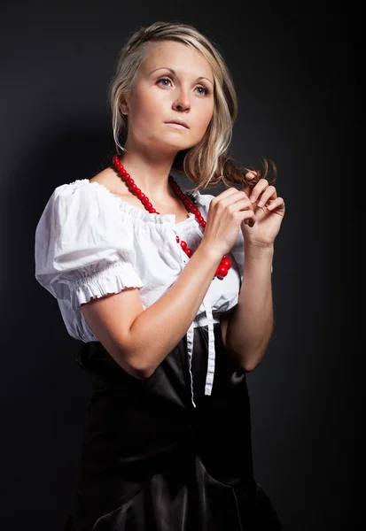 Volksfrau in Tracht, die einen Zopf flechtet — Stockfoto