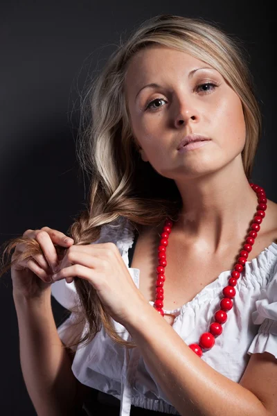 Народная женщина в фольклорной одежде плетет косу — стоковое фото
