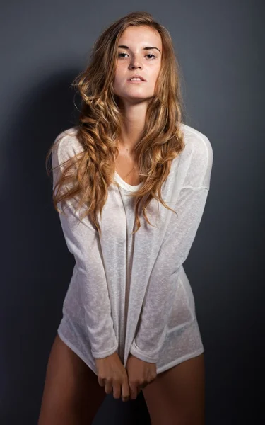Sexy Frau in weißem T-Shirt mit langen Ärmeln, dunklem Hintergrund — Stockfoto