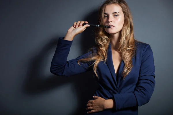 Elegante vrouw met e-sigaret dragen pak — Stockfoto