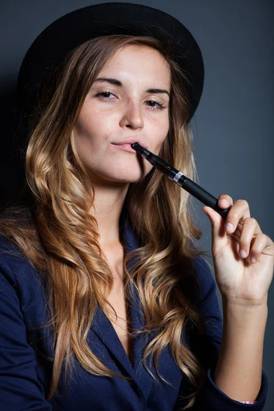 Elegantní žena drží a kouření e-cigarety — Stock fotografie