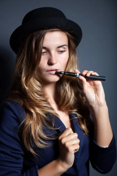 Mulher elegante fumar e-cigarro vestindo terno e chapéu — Fotografia de Stock