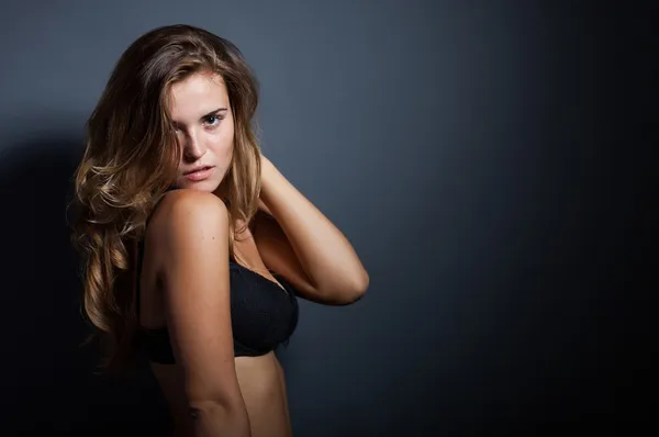 Portrét sexy ženy ve spodním prádle na tmavém pozadí — Stock fotografie