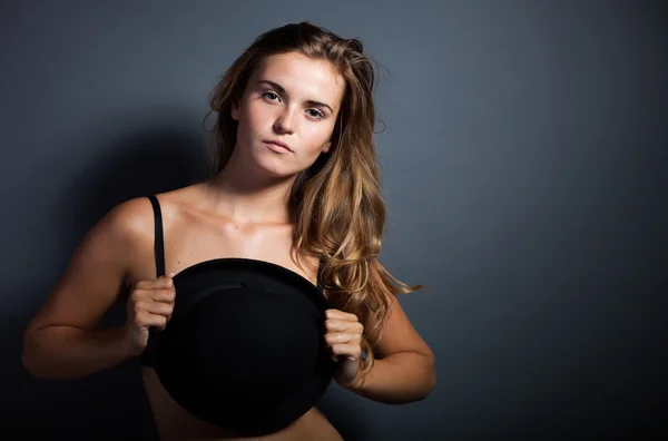 Sexy woman in lingerie holding hat, covering breast — Stock Photo, Image