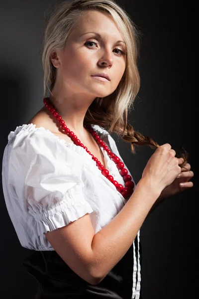 Volksfrau in Tracht, die einen Zopf flechtet — Stockfoto