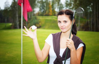 kadın golf oyuncu topu ve kulüp Kupası yakınında yeşil