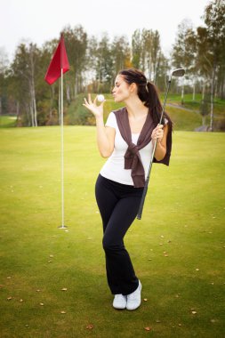 yeşil, genç kadın golf oyuncu topu öpüyor