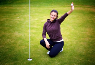 genç kadın golf oyuncu topu yukarı işareti veriyor