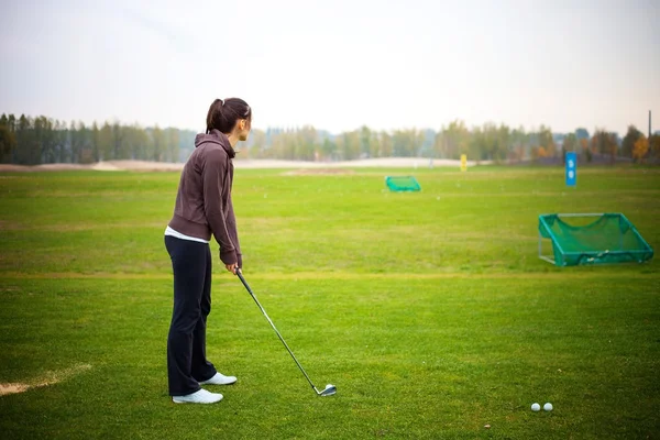 Golf školení mladá žena na driving range — Stock fotografie