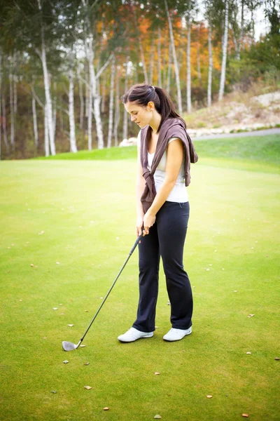 Mulher jogador de golfe formação em verde com clube — Fotografia de Stock