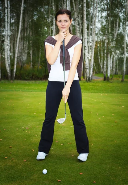 Golferin posiert auf Grün mit Schläger und Ball — Stockfoto
