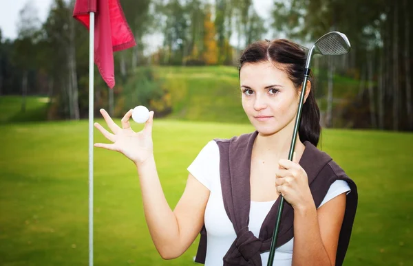 Donna giocatore di golf su verde con palla e club vicino tazza — Foto Stock