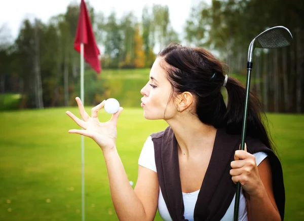 Jovem jogador de golfe mulher no verde, beijando bola — Fotografia de Stock