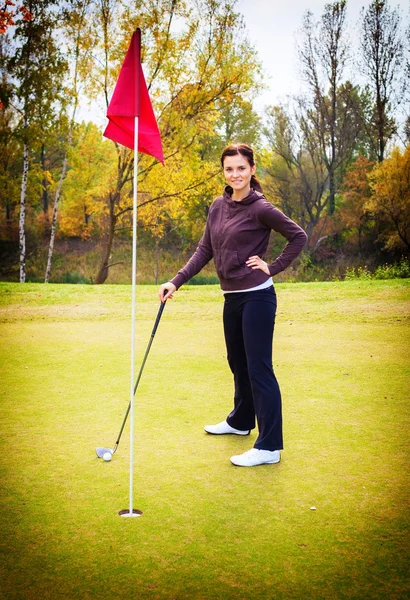 Lachende vrouw golfspeler opleiding op groen — Stockfoto