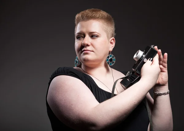 Chubby woman taking pictures of old camera — Stock Photo, Image