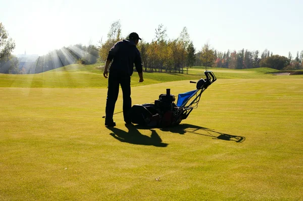 Adam golf sahası, çim biçme makinesi kullanılarak çim biçme — Stok fotoğraf