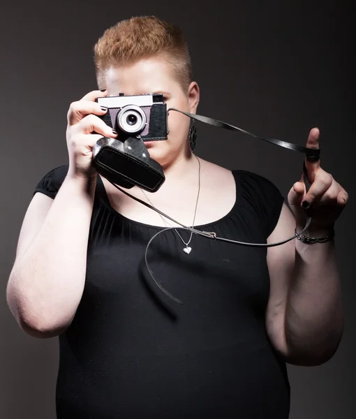 Chubby woman taking pictures of old camera — Stock Photo, Image