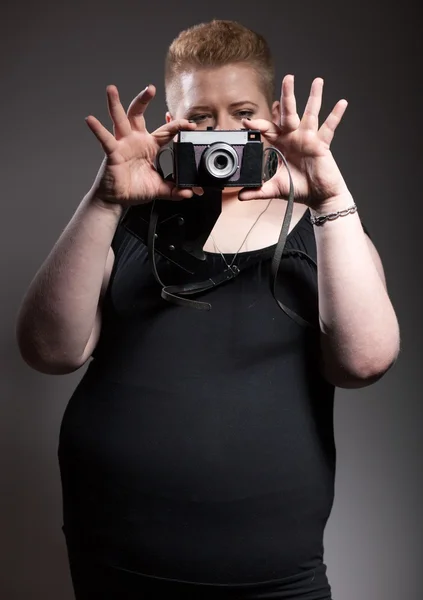 Chubby woman taking pictures of old camera — Stock Photo, Image