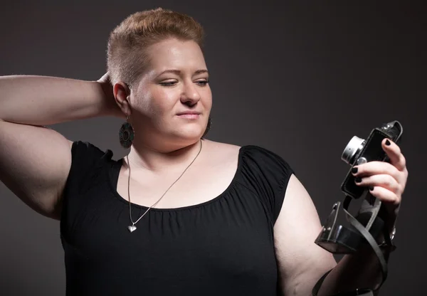 Chubby woman taking pictures of old camera — Stock Photo, Image