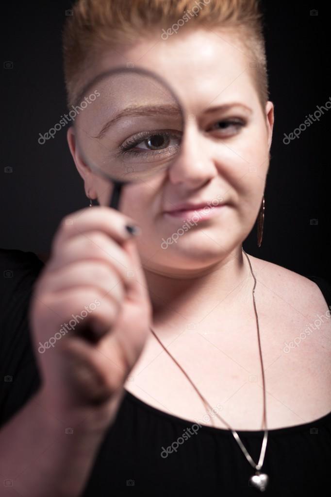 Chubby Woman With Short Hair Looking Through A Magnifying Glass
