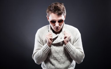 adam beyaz kazak ve güneş gözlüğü