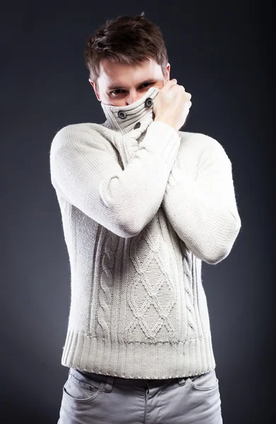 Молодой человек в белом свитере дрожит от холода — стоковое фото