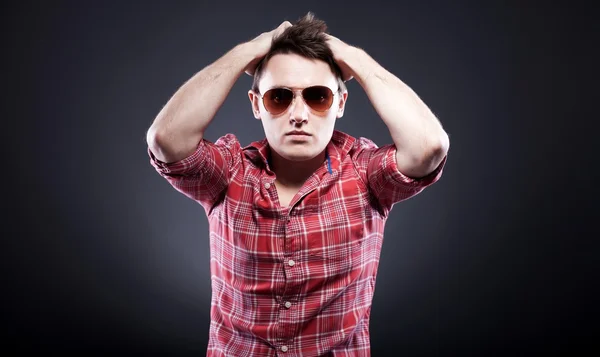 Joven guapo con gafas de sol manos en la cabeza — Foto de Stock