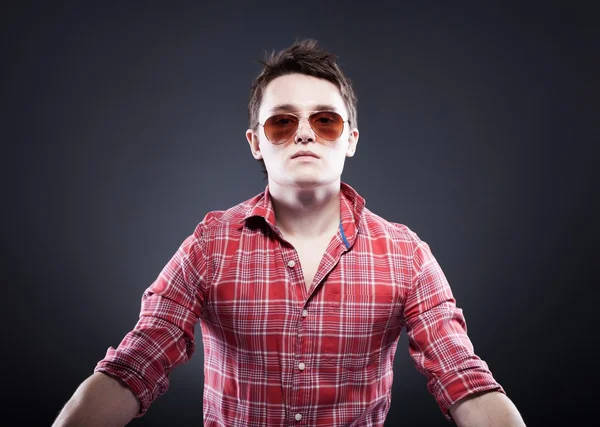 Handsome young man with sunglasses on dark background — Stock Photo, Image