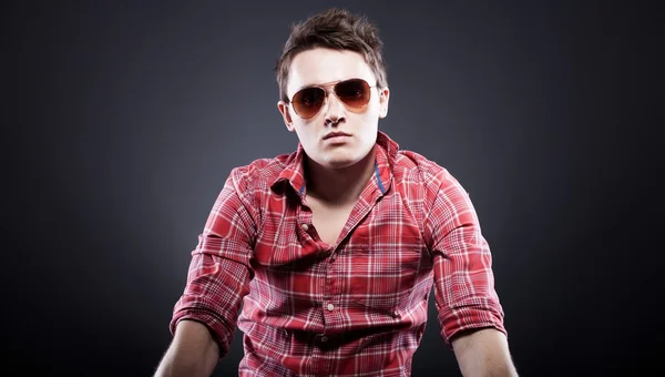 Handsome young man with sunglasses on dark background — Stock Photo, Image