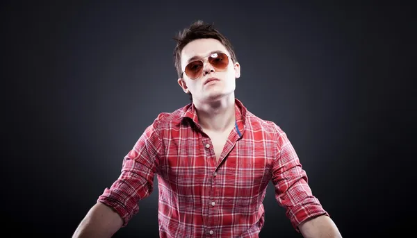 Handsome young man with sunglasses on dark background — Stock Photo, Image