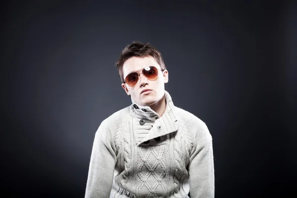 Человек в белом свитере и солнечных очках — стоковое фото
