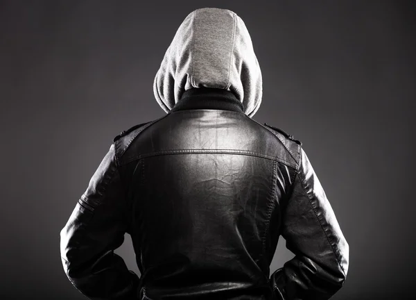 Young man in leather jacket and hood rear view — Stock Photo, Image