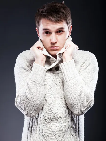 Young man in white sweater shivering from cold — Stock Photo, Image