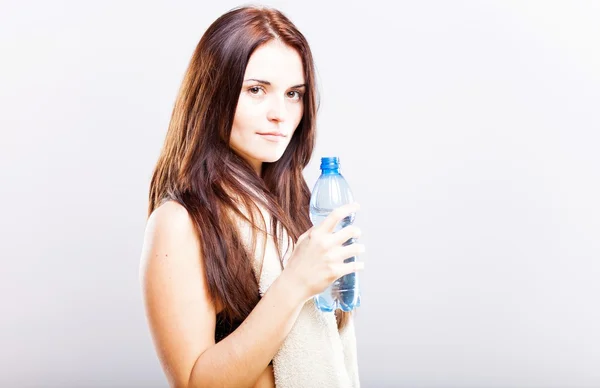 Junge Frau nach Fitness mit Handtuch und Wasserflasche — Stockfoto