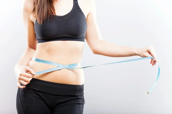 Fitness woman measuring her waistline — Stock Photo, Image