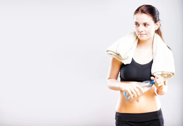 Woman after fitness class with water bottle and towel — Stock Photo, Image