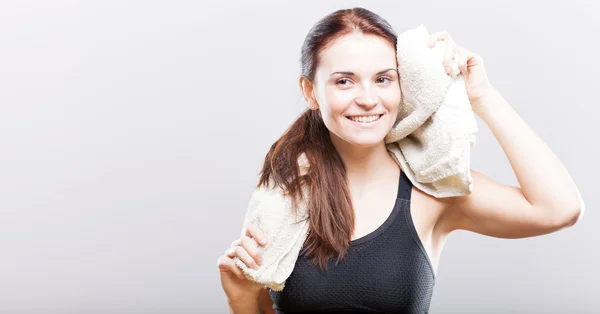 Lächelnde schöne Frau nach dem Training mit Handtuch — Stockfoto