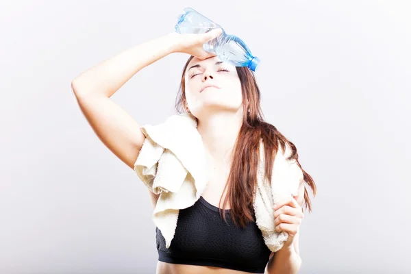 Yorgun kadın fitness havlu ve su şişesi ile sonra — Stok fotoğraf