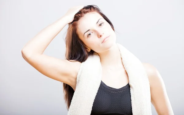 Jonge vrouw na fitnesstraining met handdoek — Stockfoto