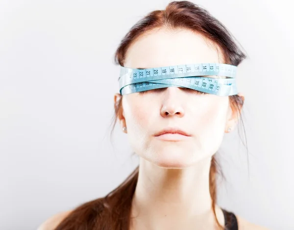 Woman with measuring tape covering her eyes — Stock Photo, Image