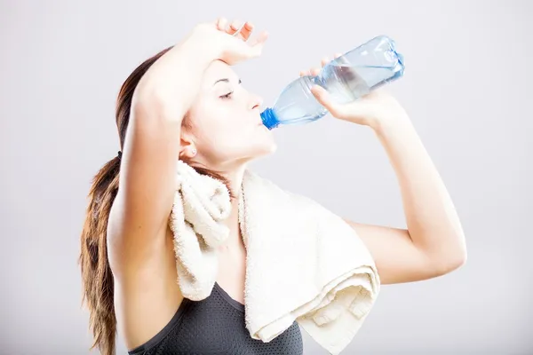 Mujer atractiva bebiendo agua después del ejercicio — Foto de Stock