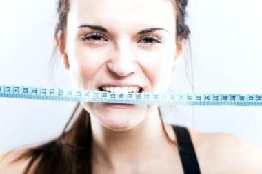 Ölçüm bandı ısırma kızgın genç kadın