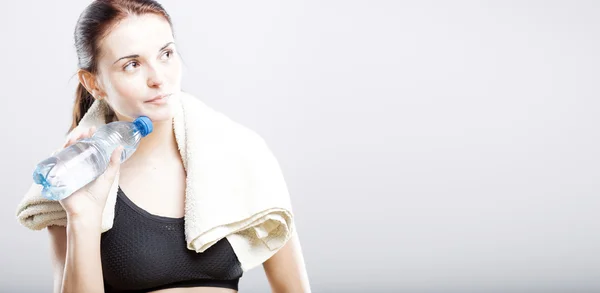 Mujer después del ejercicio con botella de agua y toalla —  Fotos de Stock