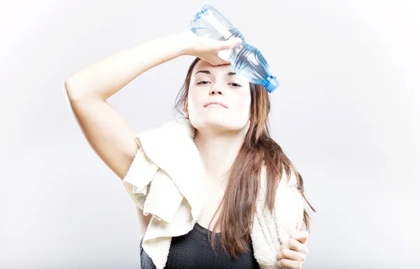 Mulher exausta com garrafa de água e toalha — Fotografia de Stock
