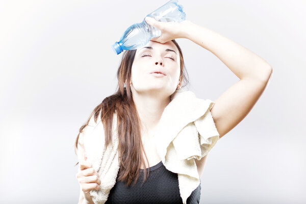 Exhausted woman with water bottle and towel